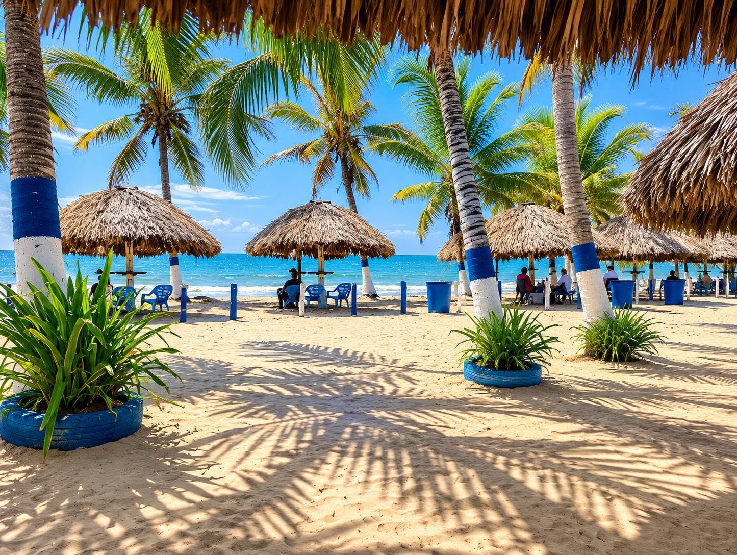 Kioscos de palma y palmeras en la playa frente a las cabañas